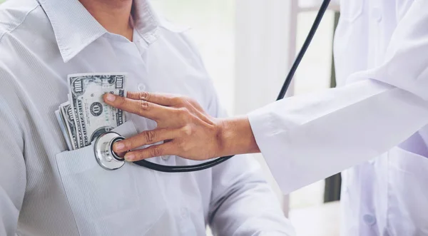 Médico recebeu dinheiro de corrupção, mão colocando dinheiro no paciente — Fotografia de Stock