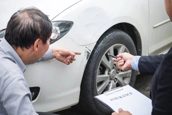 Homem agente de preenchimento formulário de seguro quase danificado e examinando carro , — Fotografia de Stock