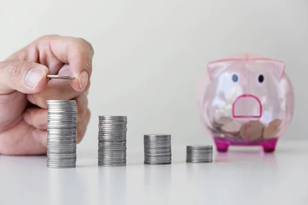 Homme d'affaires mettre des pièces de monnaie augmenter la croissance à un bureau et un cochon — Photo