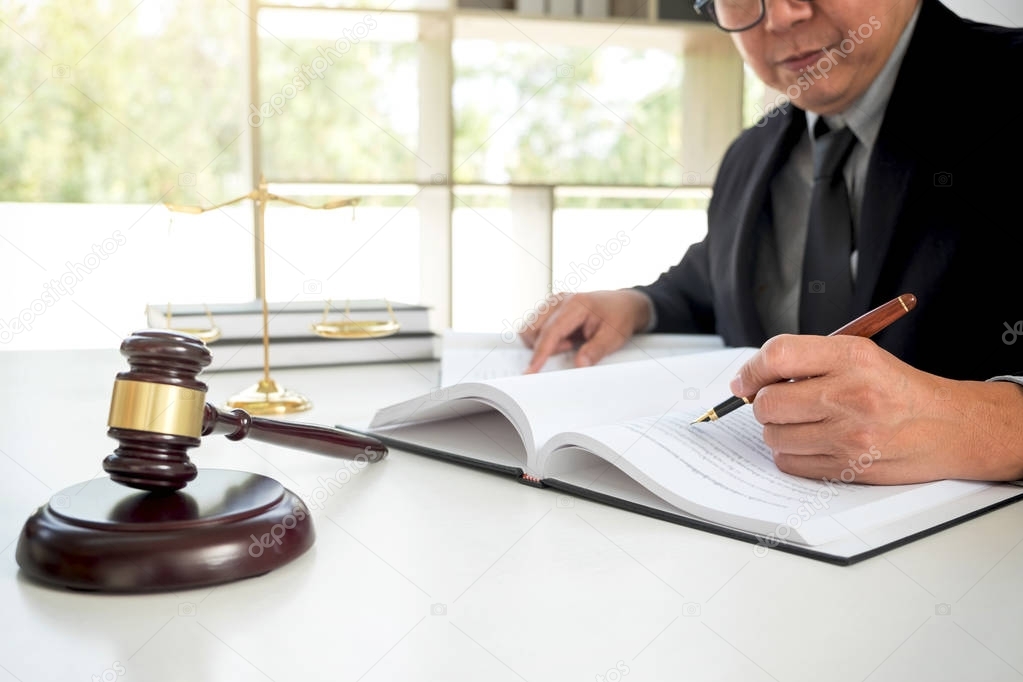 Gavel on wooden table and Lawyer or Judge working with agreement