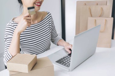 Mutlu kadın akıllı telefon ve kredi kartı kullanarak kayıt ödemeleri 