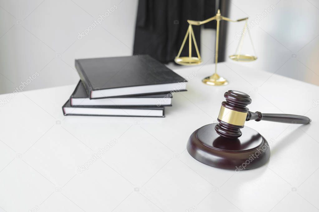 Attorney's suit, Law books, a gavel and scales of justice on a w