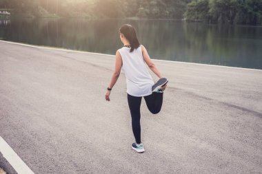 Atlet kadının bazı germe egzersizleri bacaklar runnin önce yapması