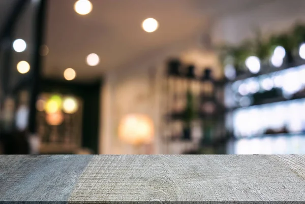 Boş ahşap masa ve bulanık arka plan önünde o soyut — Stok fotoğraf