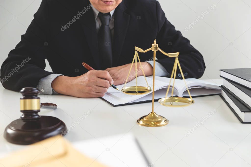 Gavel on wooden table and Lawyer or Judge working with agreement