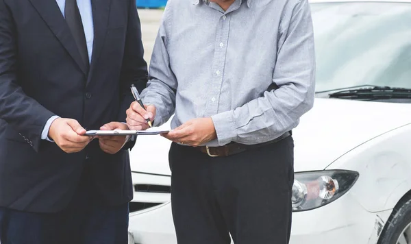 Verzekeringsagent onderzoeken auto beschadigd en klant signatur indienen — Stockfoto