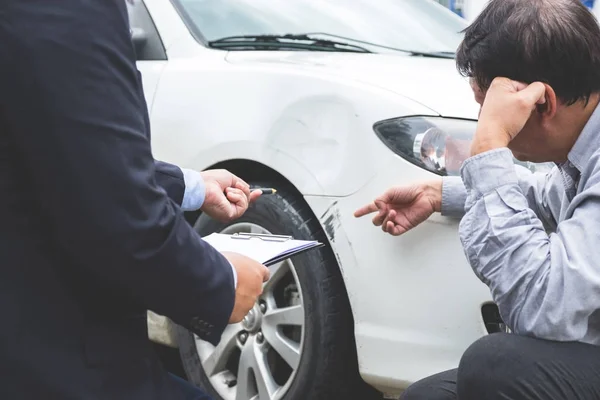 Agent d'homme remplissant le formulaire d'assurance près endommagé et examinant la voiture , — Photo