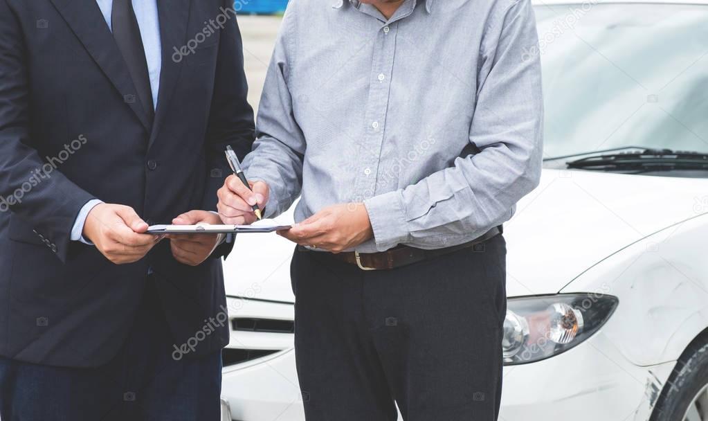 Insurance Agent examine Damaged Car and customer filing signatur