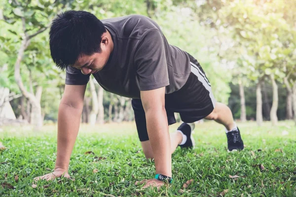 Mannen push-up motion träning fitness gör utanför på gräset i — Stockfoto