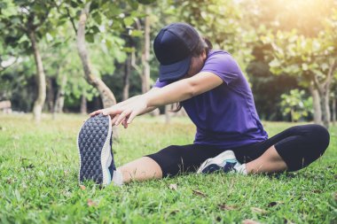 Sporcu kadın Koşudan önce ısınmak bazı germe egzersizleri yapıyor