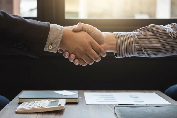 Due uomini d'affari che si stringono la mano durante una riunione per firmare accordi — Foto Stock