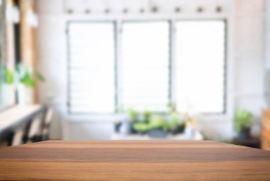 Boş ahşap masa ve soyut restoran veya kahve dükkanı için ürün görüntüsünü veya montaj için önünde arka plan bulanık.