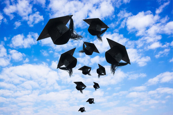 Graduation day, Images of graduation Caps or hat throwing in the air with sunshine day on blue sky background, Happiness feeling, Commencement day, Congratulation, Ceremony.