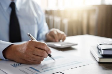 Erkek muhasebeci hesaplamalar ve mali grafik verilerini çözümleme 