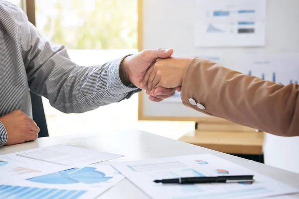 Двоє бізнесменів тремтять руками під час зустрічі, щоб підписати угоду — стокове фото