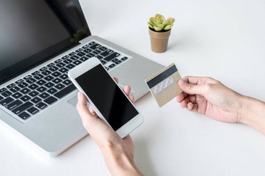Mutlu kadın akıllı telefon ve kredi kartı kullanarak kayıt ödemeleri 