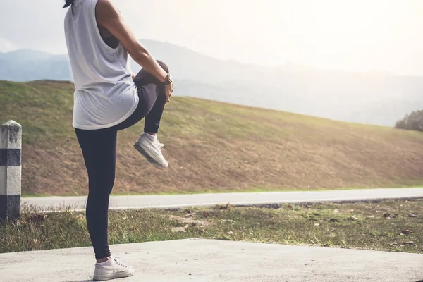 Idrottsman kvinna gör vissa stretching övningar ben innan runnin — Stockfoto