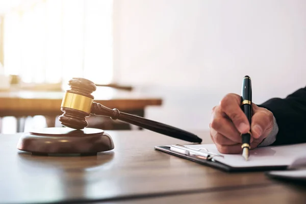 Молоток на деревянном столе и адвокат или судья, работающий по соглашению — стоковое фото