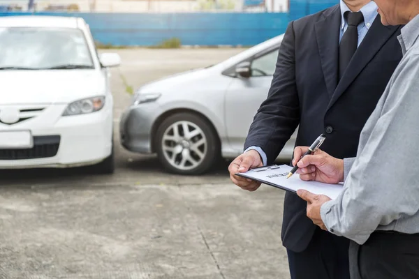 Agente de seguros examinar carro danificado e cliente assinaturr arquivamento — Fotografia de Stock