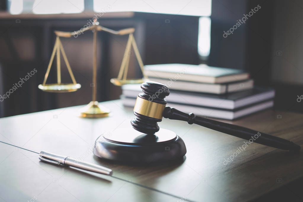 Scales of justice and Gavel on wooden table and Lawyer or Judge 