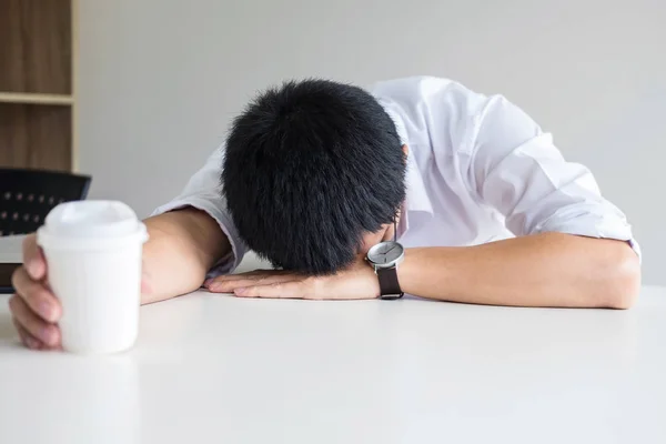 Unavený podnikatel spaní v práci v moderní kanceláři rukou ho — Stock fotografie