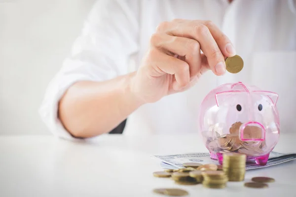 Empresario poniendo monedas en alcancía y utilizando la calculadora t — Foto de Stock