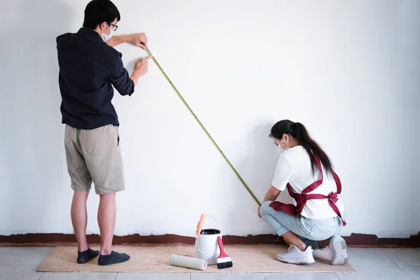 Внутренняя работа, два художника с измерительной стеной для проверки ленты — стоковое фото