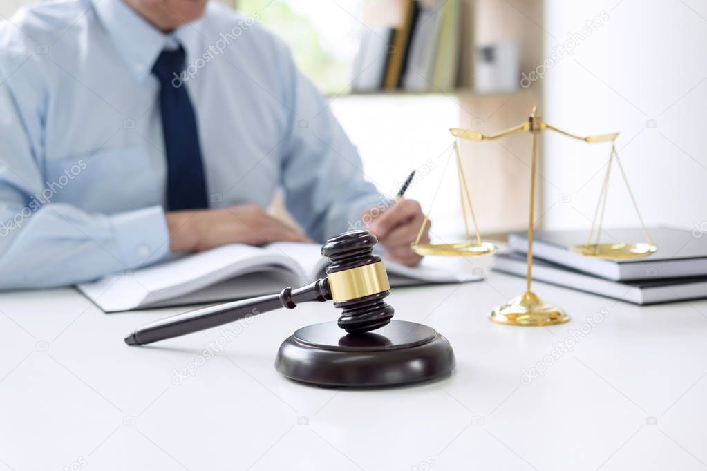 Judge gavel with scales of justice, male lawyers working having 