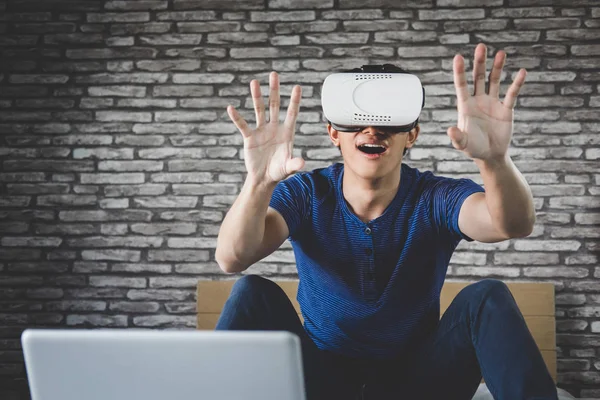 Hombre joven con auriculares de realidad virtual o gafas 3D jugando video —  Fotos de Stock