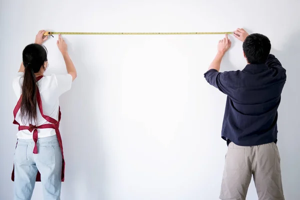 Interiör arbetar, två målare med åtgärd tejp kontrollera väggen le — Stockfoto