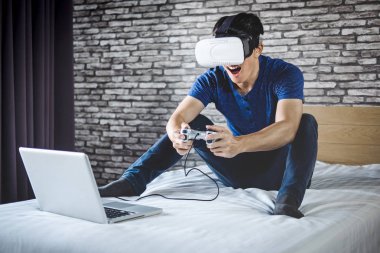 Genç adam yatak odasında sanal gerçeklik kulaklık veya 3d g eğlence var