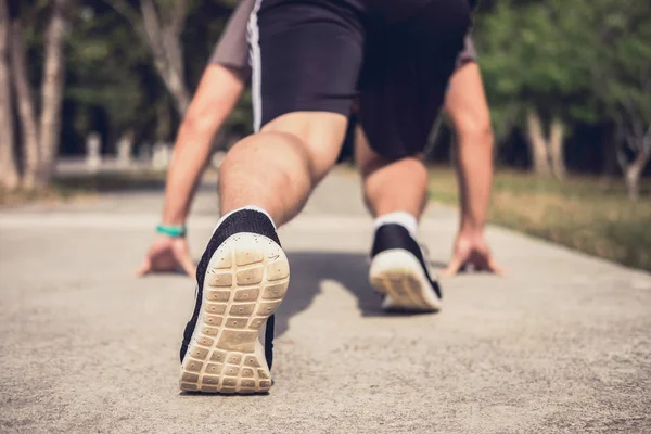 Närbild på skor, idrottsman löpare fötter kör på väg att börja — Stockfoto