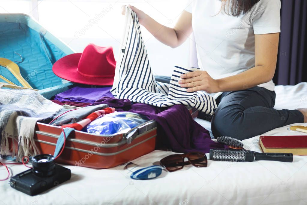 Travel and vacation concept, happiness woman packing stuff and a