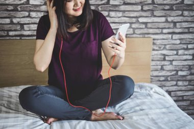 Genç kadın var eğlenceli dinle zevk yatak üzerinde müzik zekâ