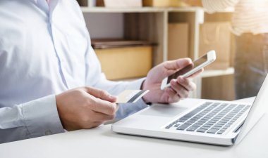 Ödemeler kayıt akıllı telefon ve kredi kartı kullanan adam