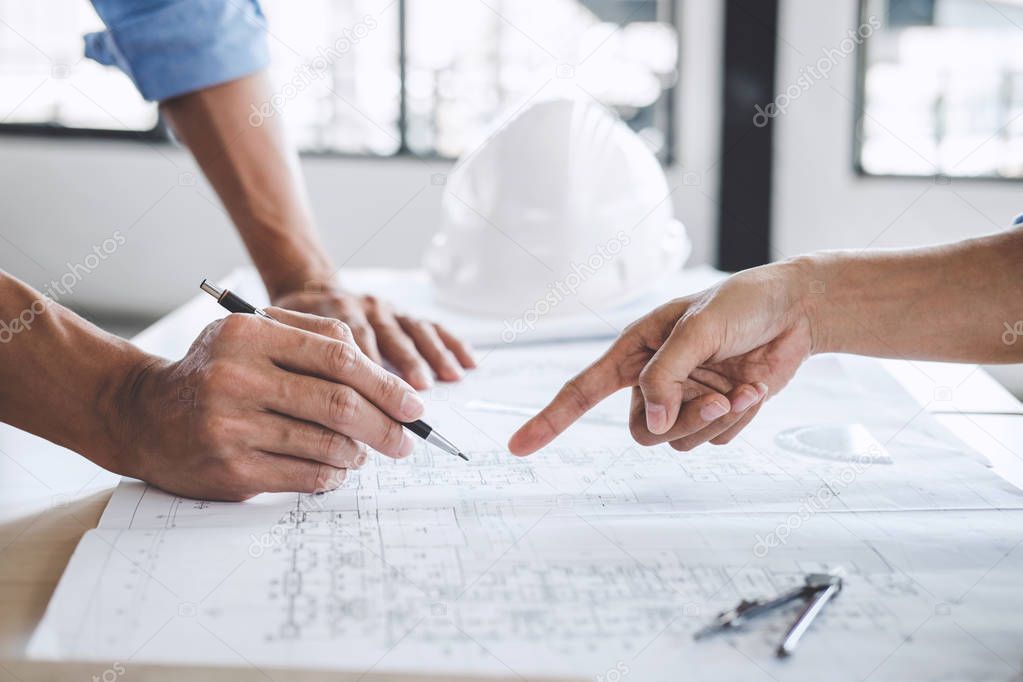 Hands of architect or engineer working on blueprint meeting for 