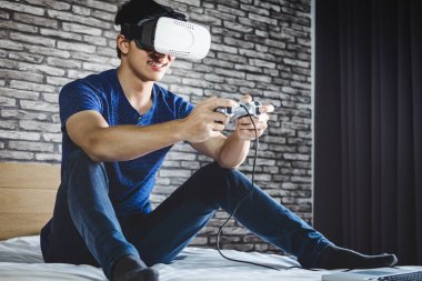 Genç adam yatak odasında sanal gerçeklik kulaklık veya 3d g eğlence var