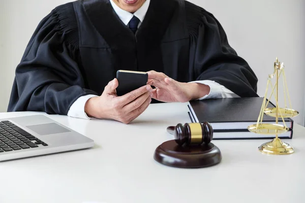 Manliga advokat eller domare arbetar med smart telefon och skalor av bara — Stockfoto