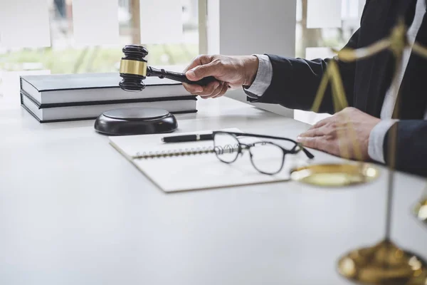 Männlicher Rechtsanwalt oder Richter, der mit Vertragsunterlagen, Gesetzesbüchern und — Stockfoto