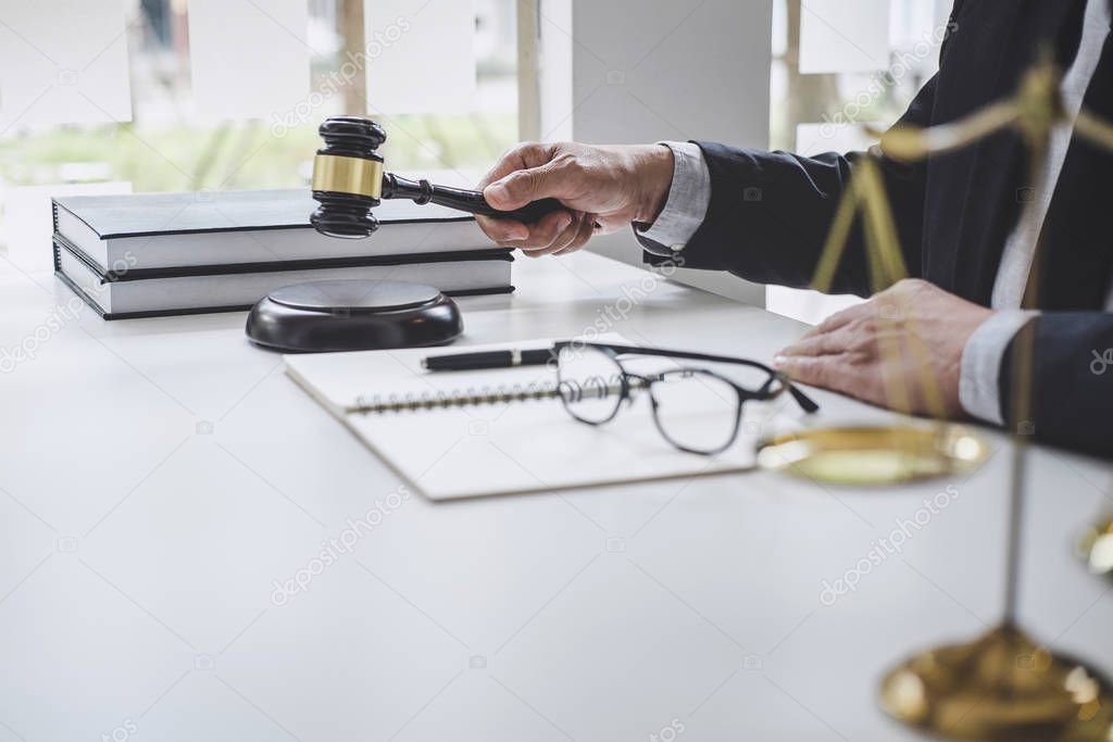 Male lawyer or judge working with contract papers, Law books and