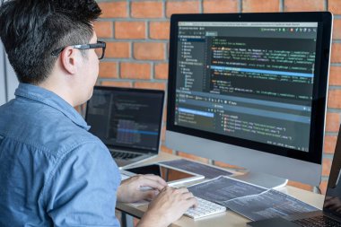 Bir yazılım geliştirme ofisinde çalışan, kod yazan ve veri kodu yazan, HTML, PHP ve javascript ile programlanan genç Profesyonel programcı.