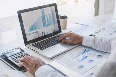Yeni iş stratejisi ve işyerindeki piyasa büyümesi projesi için finansal belge veri grafiğinin istatistiklerini hesaplayarak laptopta çalışan ve analiz eden profesyonel işadamı.