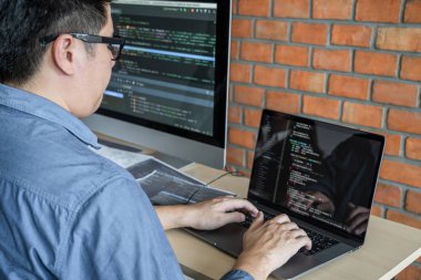 Bir yazılım geliştirme ofisinde çalışan, kod yazan ve veri kodu yazan, HTML, PHP ve javascript ile programlanan genç Profesyonel programcı.