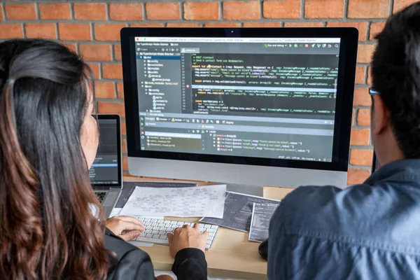 Yazılım geliştirme ofisinde çalışan, kod yazan ve veri kodu yazan programcılar, HTML, PHP ve javascript ile programlama.