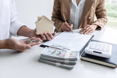Emlakçı Satış yöneticisi müşteriye dosyalama anahtarları tutan 