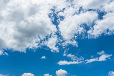 Mavi gökyüzü güneş ışığı altında beyaz bulutlar ile