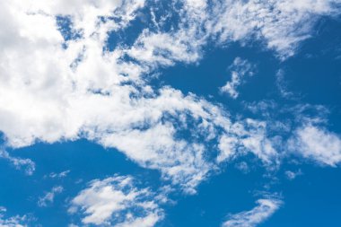 Mavi gökyüzü güneş ışığı altında beyaz bulutlar ile.