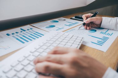 Ofis Büro ve diğer nesnelerin çevresine hesap makinesi ile bir grafik belge mali rapor ve analiz hesaplama yatırım maliyeti üzerinde çalışan iş adamı.