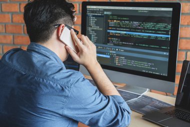 Bir yazılım geliştirme ofisinde çalışan, kod yazan ve veri kodu yazan, HTML, PHP ve javascript ile programlanan genç Profesyonel programcı.