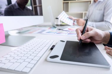 Renk seçimi ve renk örnekleri üzerinde çalışan iki iş arkadaşı yaratıcı grafik tasarımcısı, çalışma araçları ve aksesuarlarla iş yerindeki grafik tabletine çizim yapıyor.